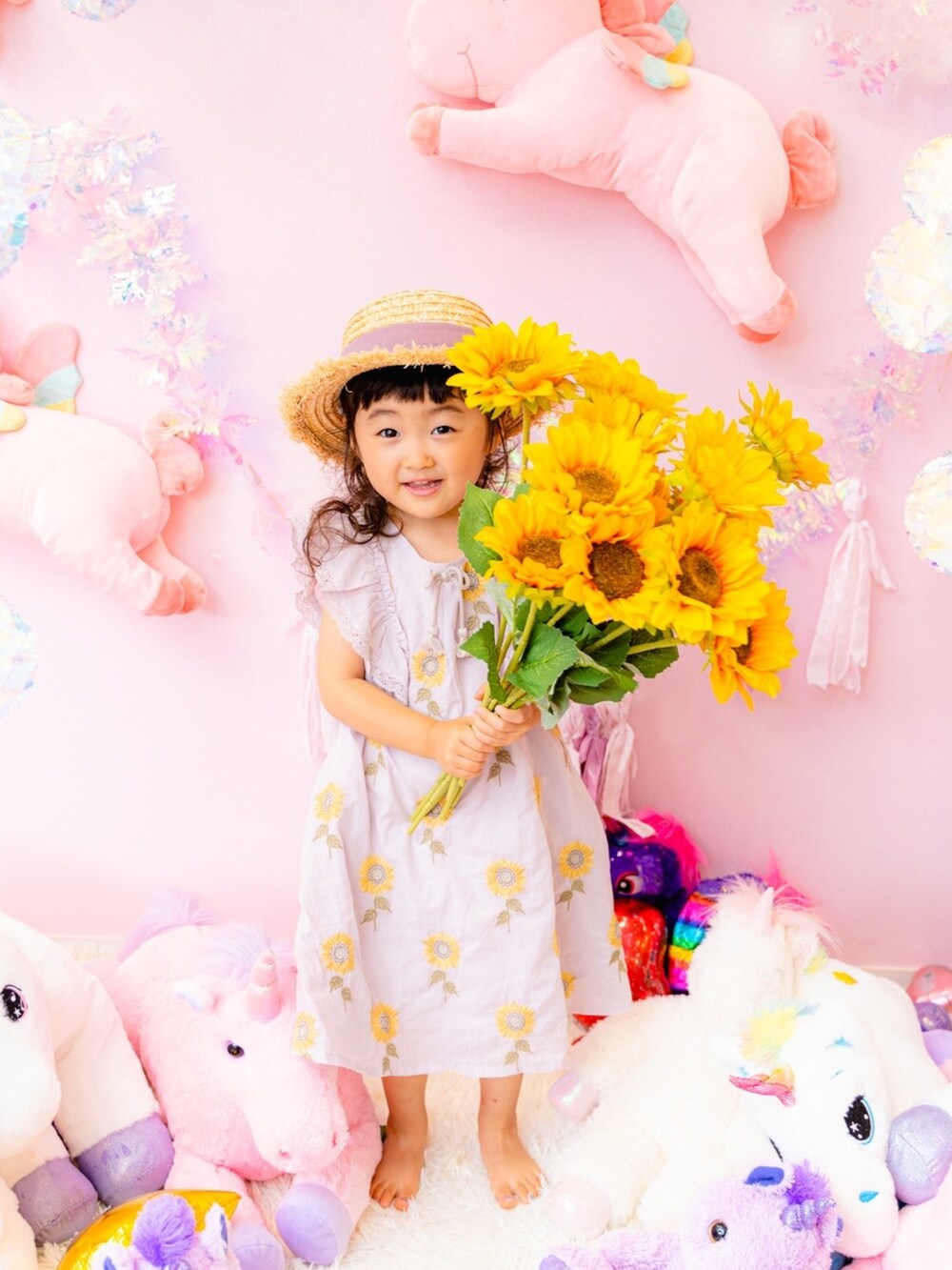 パープル系のワンピース、ベージュ系の帽子を着用したキッズの冬コーディネートの2枚目の写真