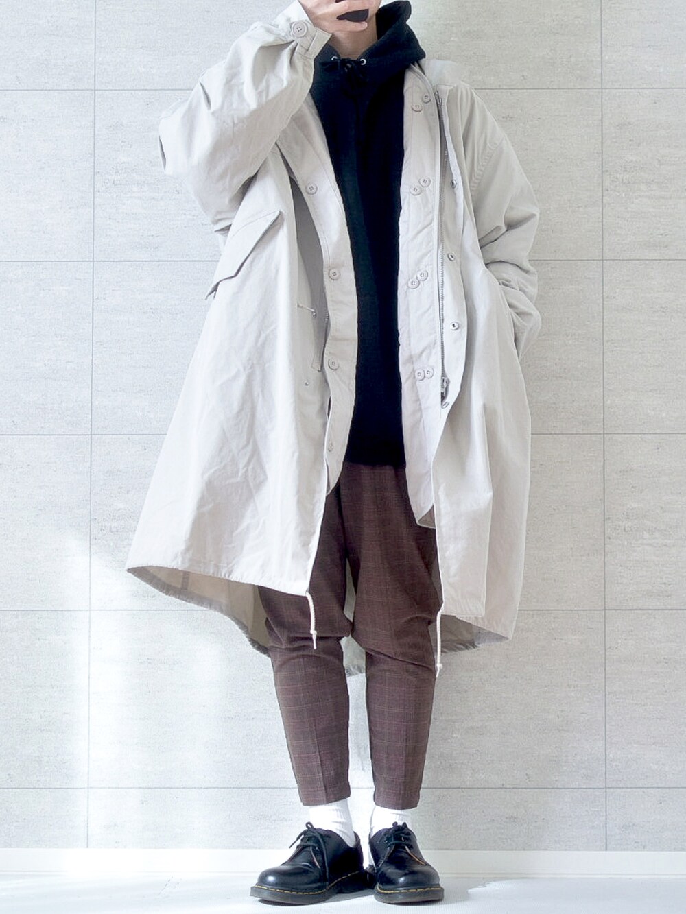 ホワイト系のその他アウター、ブラウン系のスラックス、ブラック系のブーツを着用したメンズの冬コーディネートの2枚目の写真