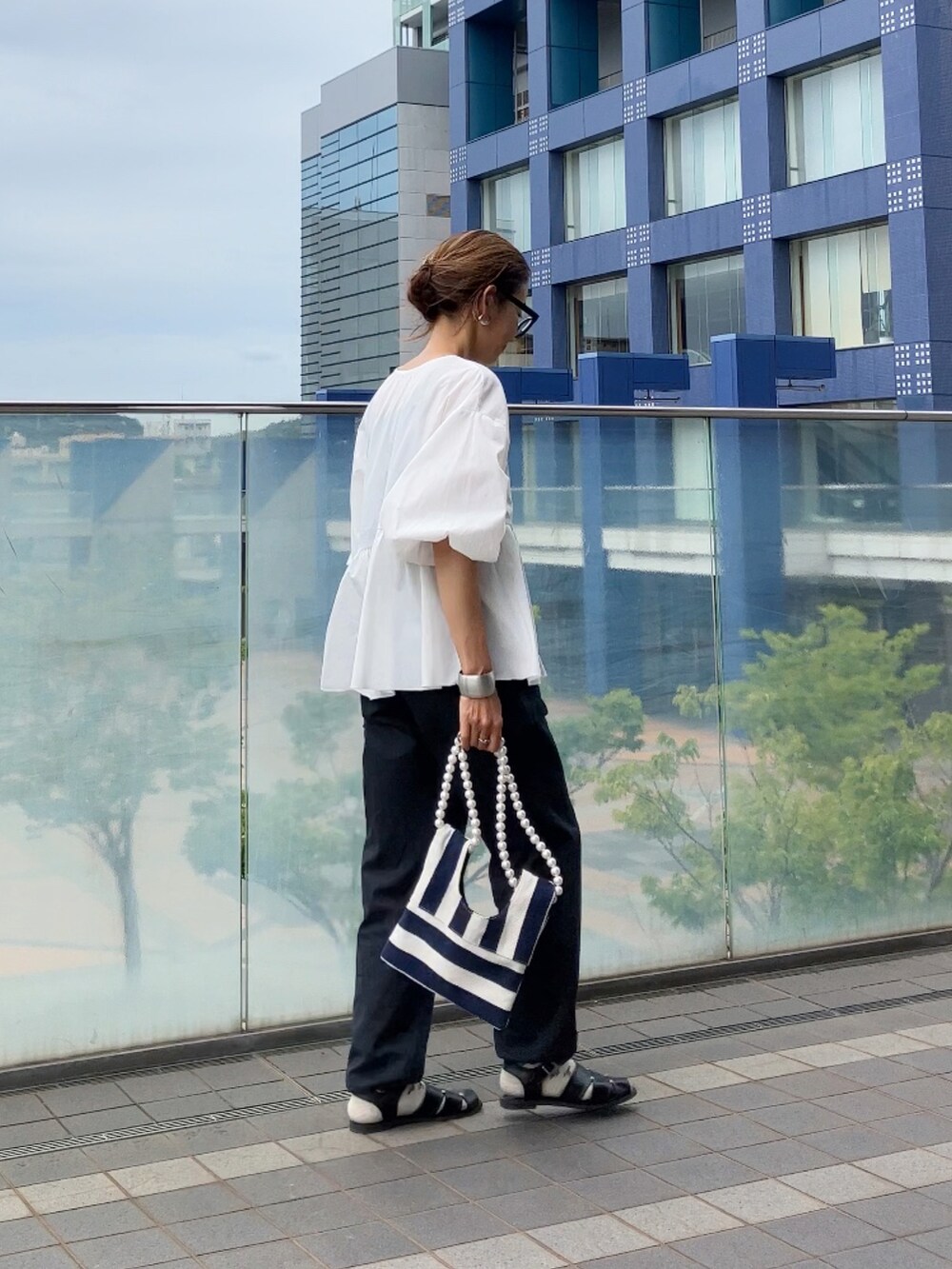 ホワイト系のシャツ/ブラウス、ホワイト系のショルダーバッグを着用したレディースの夏コーディネートの2枚目の写真