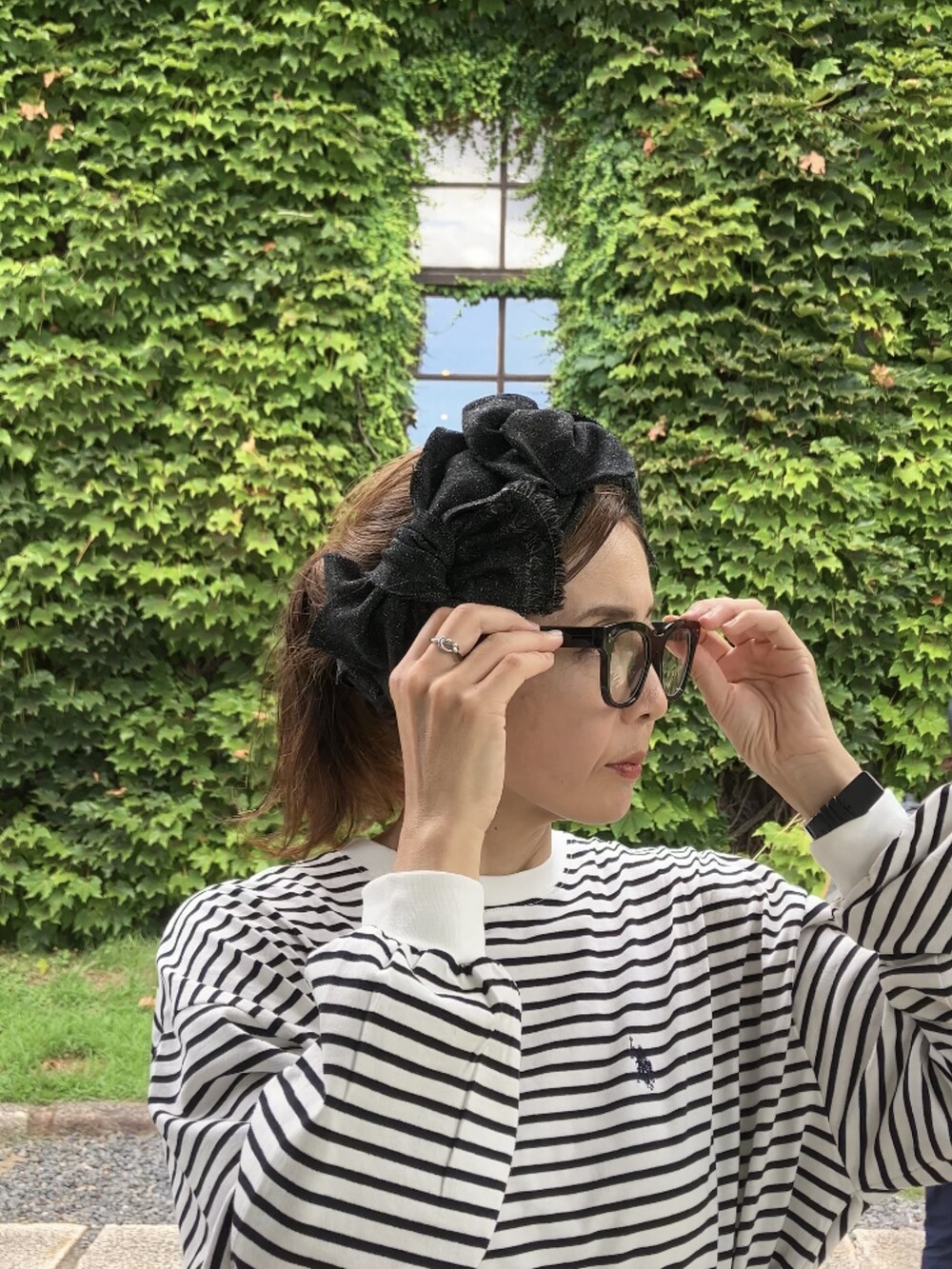 ブラック系のTシャツ/カットソー、ブラック系のスカート、ホワイト系のハンドバッグを着用したレディースの夏コーディネートの2枚目の写真