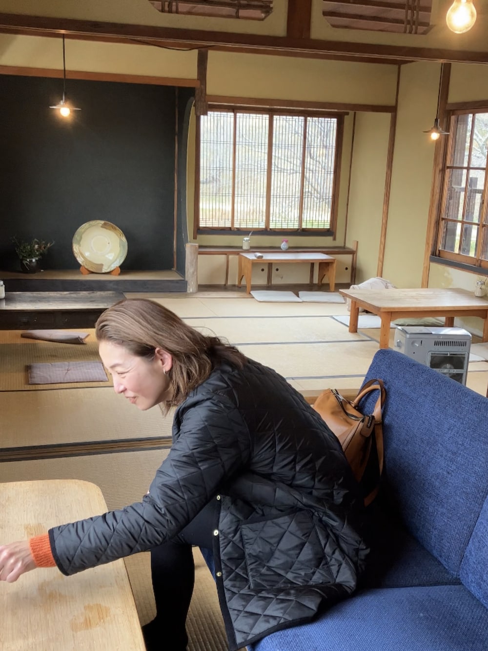 ホワイト系のTシャツ/カットソー、オレンジ系のカーディガン/ボレロ、ブラック系のその他アウターを着用したレディースの冬コーディネートの3枚目の写真