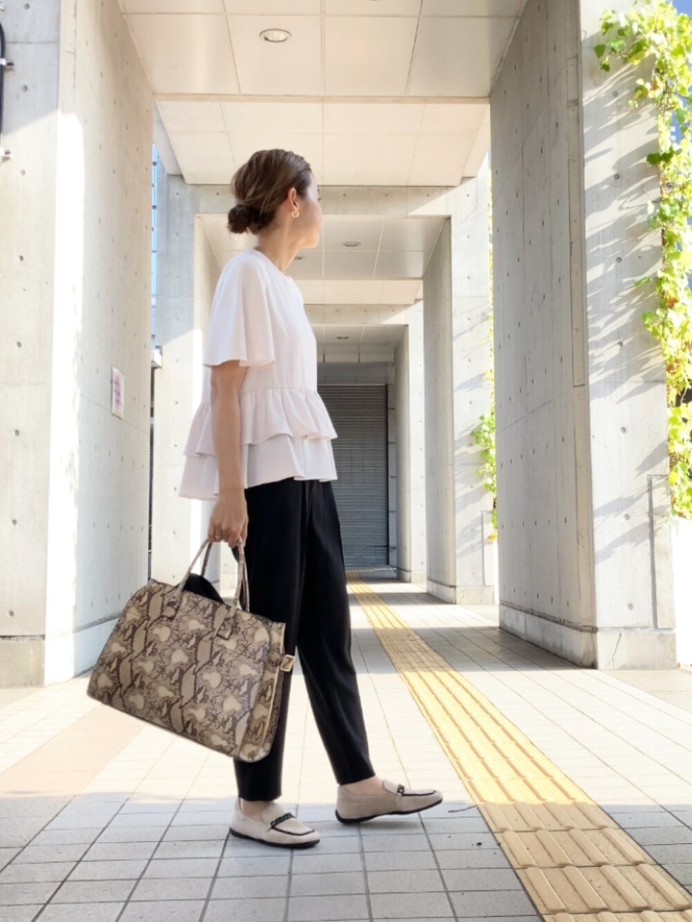 ブラック系のスーツセット、ホワイト系のスーツセット、ベージュ系のシューズを着用したレディースの夏コーディネートの2枚目の写真