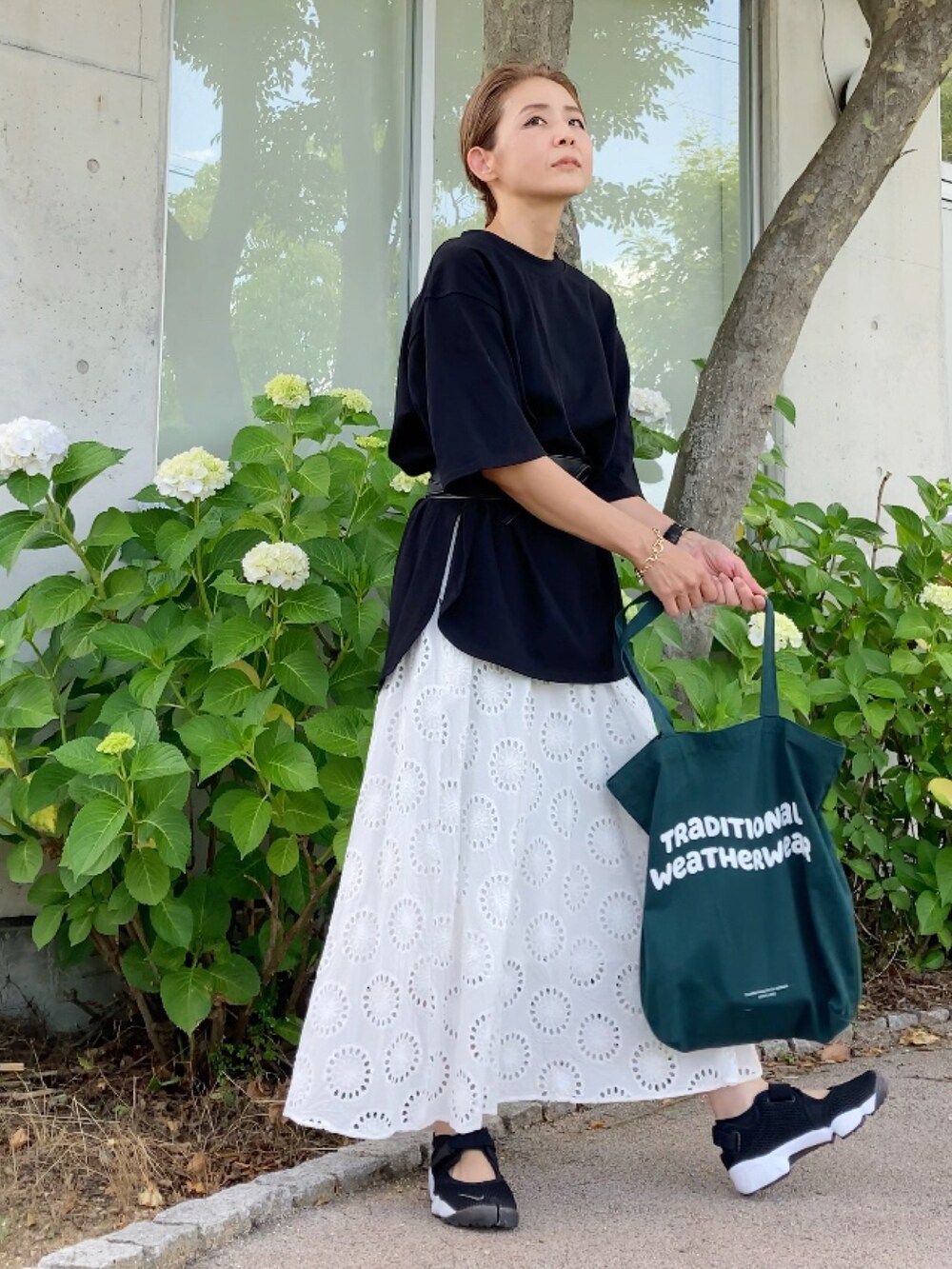 ブラック系のTシャツ/カットソー、ホワイト系のワンピース/ドレス、ブラック系のサンダルを着用したレディースの夏コーディネートの3枚目の写真