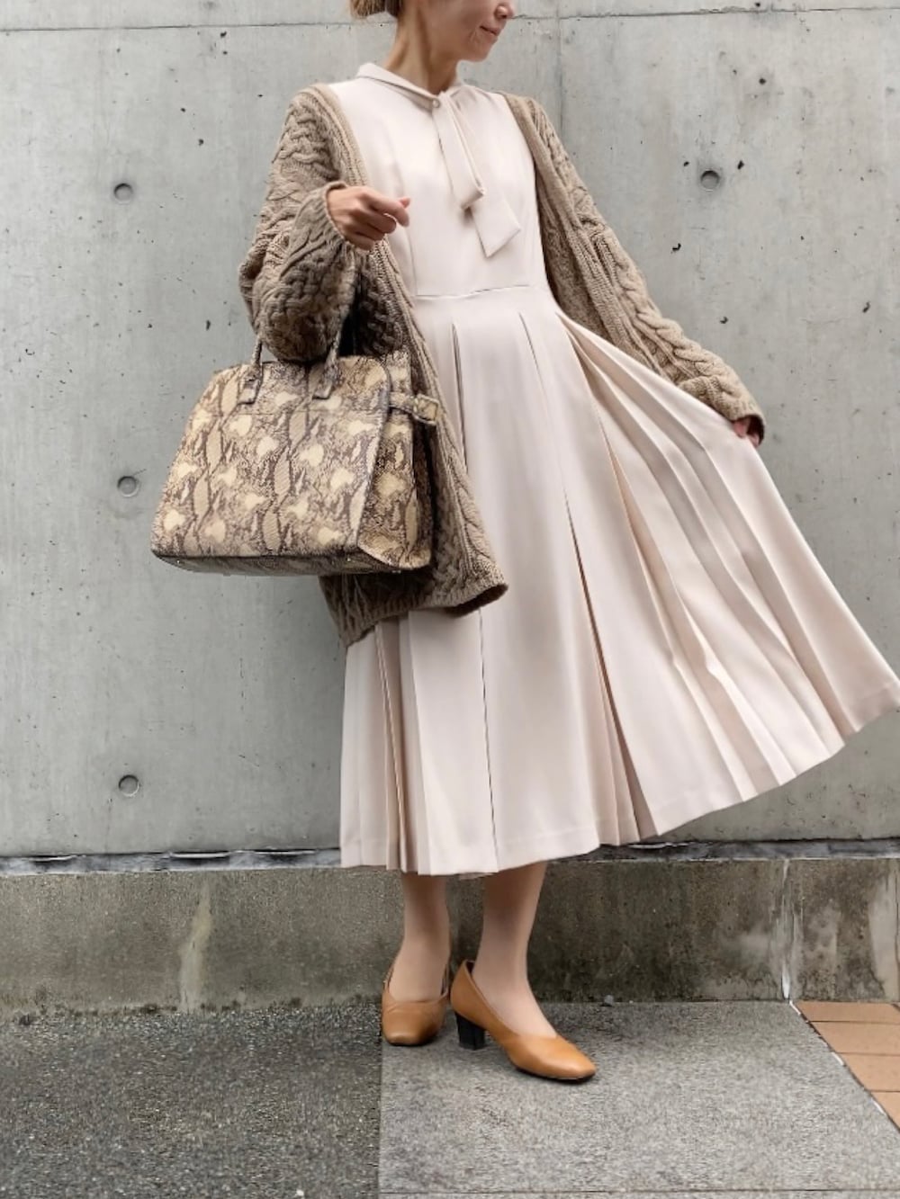 ベージュ系のカーディガン/ボレロ、その他のバッグ、ベージュ系のパンプスを着用したレディースの秋コーディネートの4枚目の写真