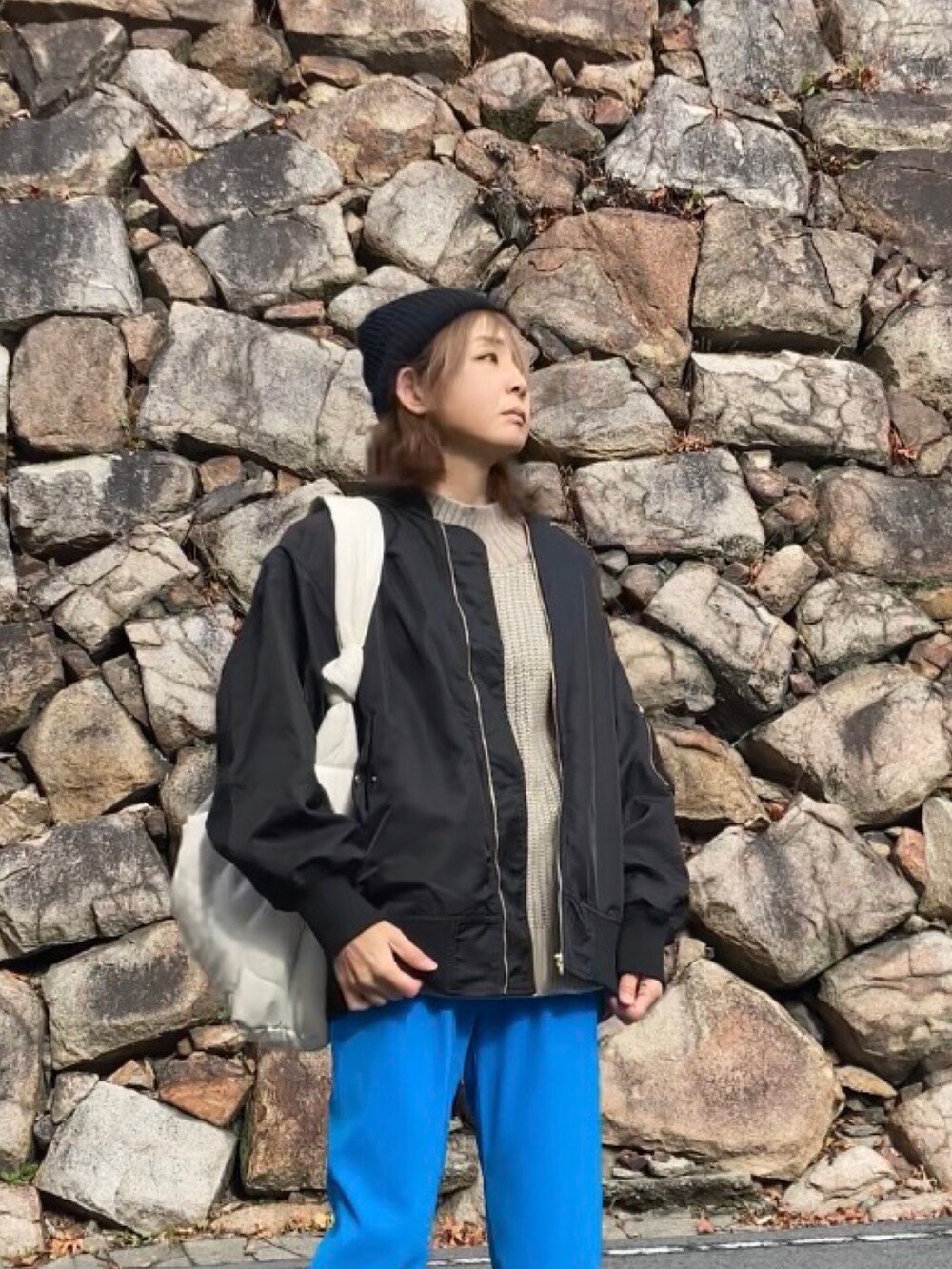 ブルー系のその他パンツ、ブラック系のブルゾン、ベージュ系のニット/セーターを着用したレディースの冬コーディネートの3枚目の写真