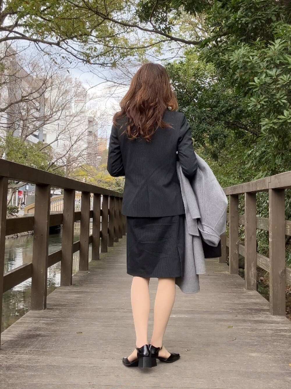 ブラック系のパンプス、グレー系のフォーマルスーツ/小物、ブラック系のビジネスバッグを着用したレディースの春コーディネートの3枚目の写真