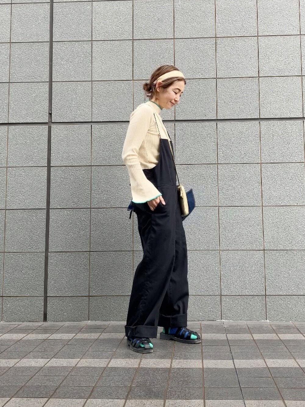 ブラック系のサロペット/オーバーオール、ホワイト系のニット/セーター、ブルー系のデニムジャケットを着用したレディースの春コーディネートの5枚目の写真