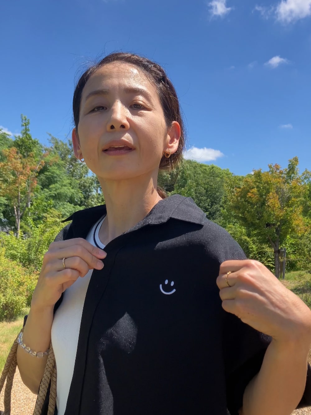 ブラック系のスラックス、イエロー系のサンダル、ベージュ系のキャップを着用したレディースの夏コーディネートの5枚目の写真