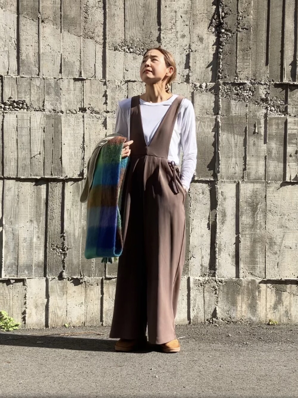 ブラウン系のサロペット/オーバーオール、ホワイト系のTシャツ/カットソー、ホワイト系のカーディガン/ボレロを着用したレディースの秋コーディネートの5枚目の写真