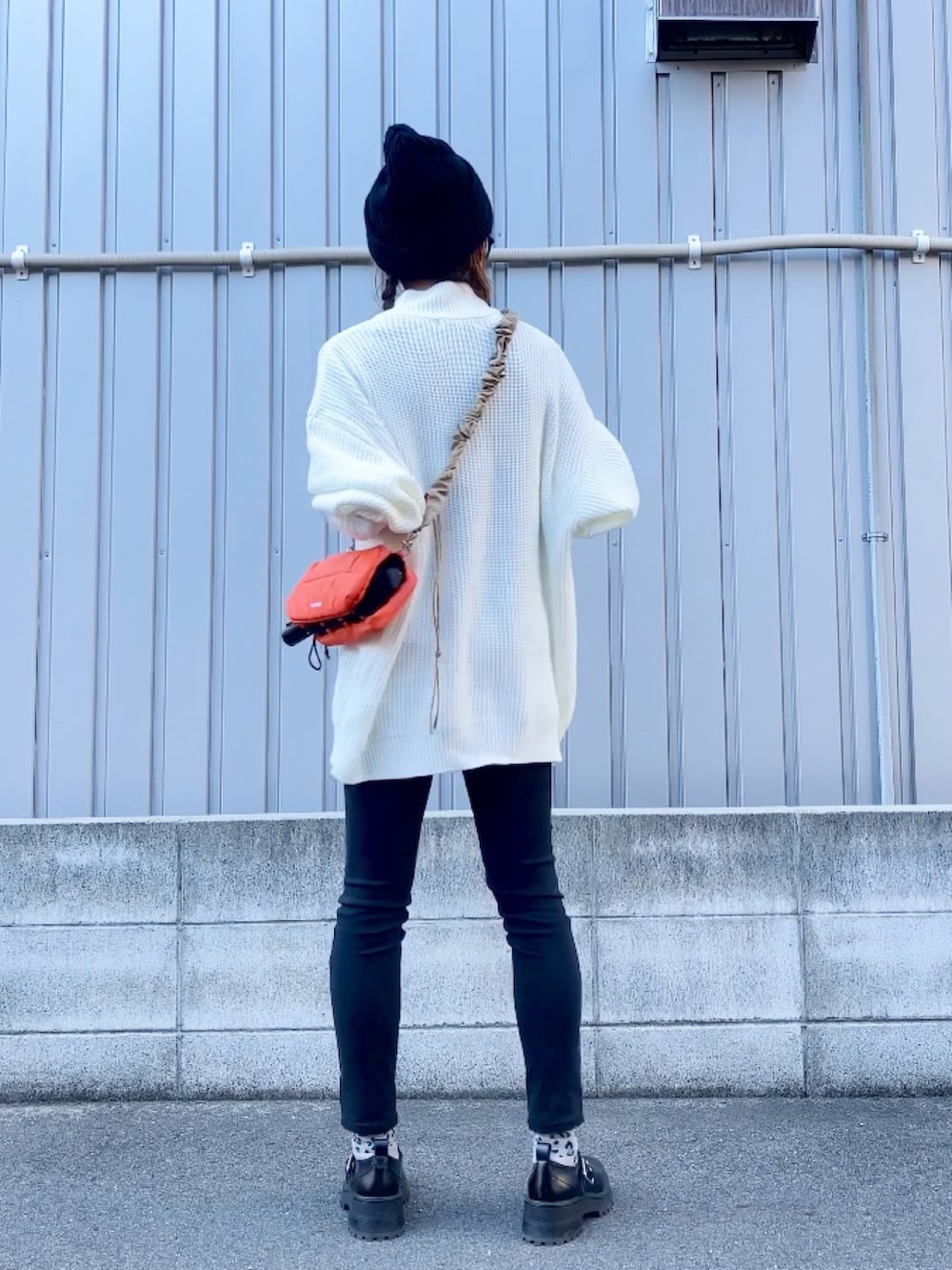 ホワイト系のニット/セーター、オレンジ系のショルダーバッグ、ブラック系のシューズを着用したレディースの秋コーディネートの4枚目の写真
