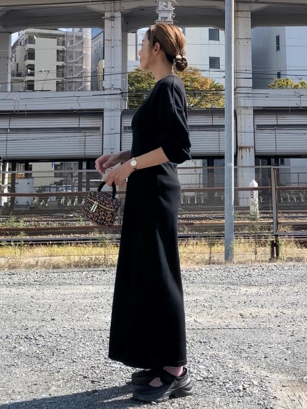 ブラック系のワンピース、その他のハンドバッグ、ブラック系のシューズを着用したレディースの秋コーディネートの3枚目の写真