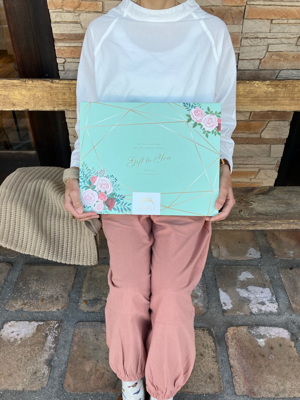 ブルー系のパンツ、ホワイト系のニット/セーター、ブラック系のサンダルを着用したレディースの春コーディネートの5枚目の写真