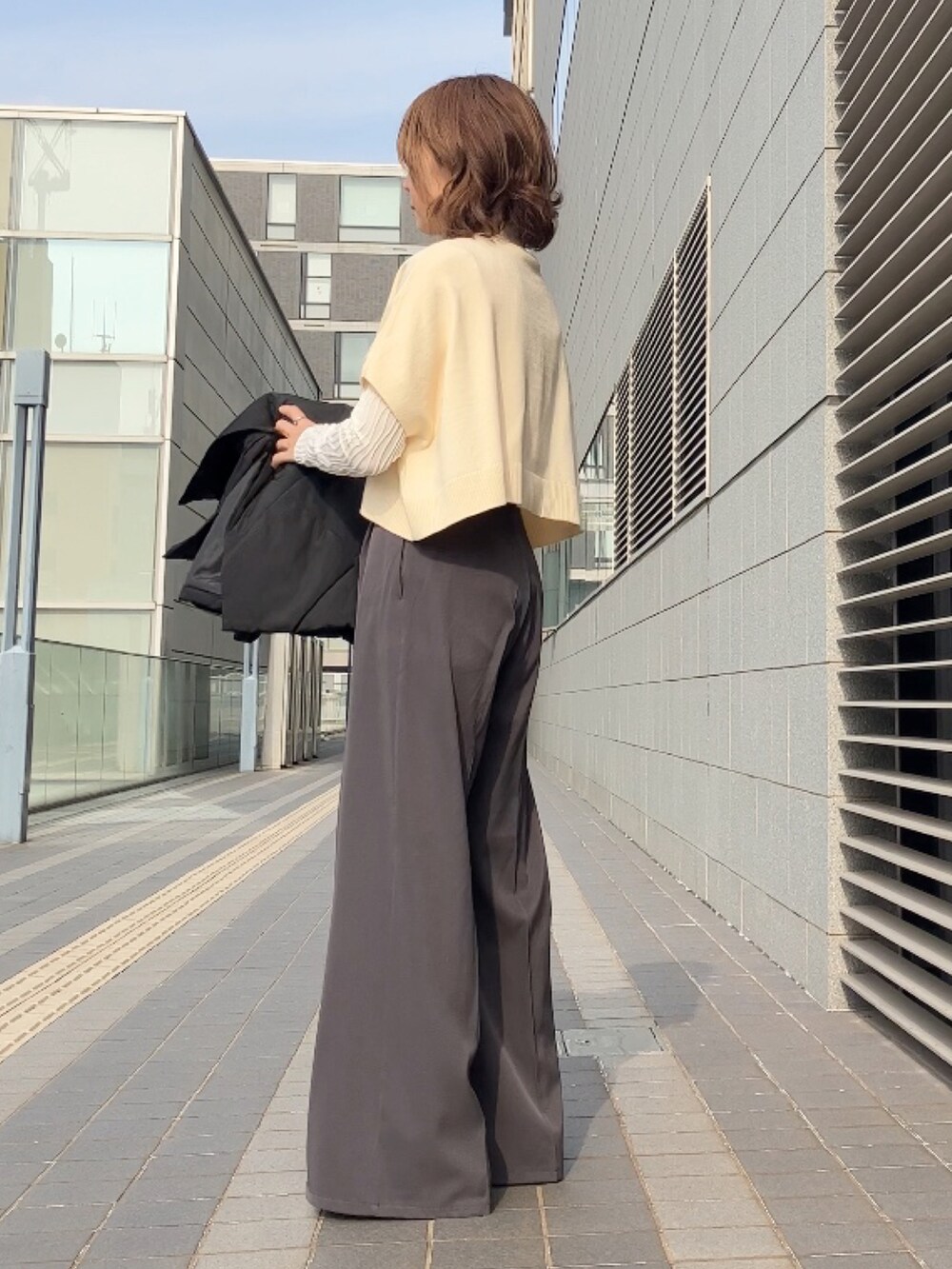 ブラック系のダウンジャケット/コート、ホワイト系のワンピース、グレー系のその他パンツを着用したレディースの冬コーディネートの2枚目の写真