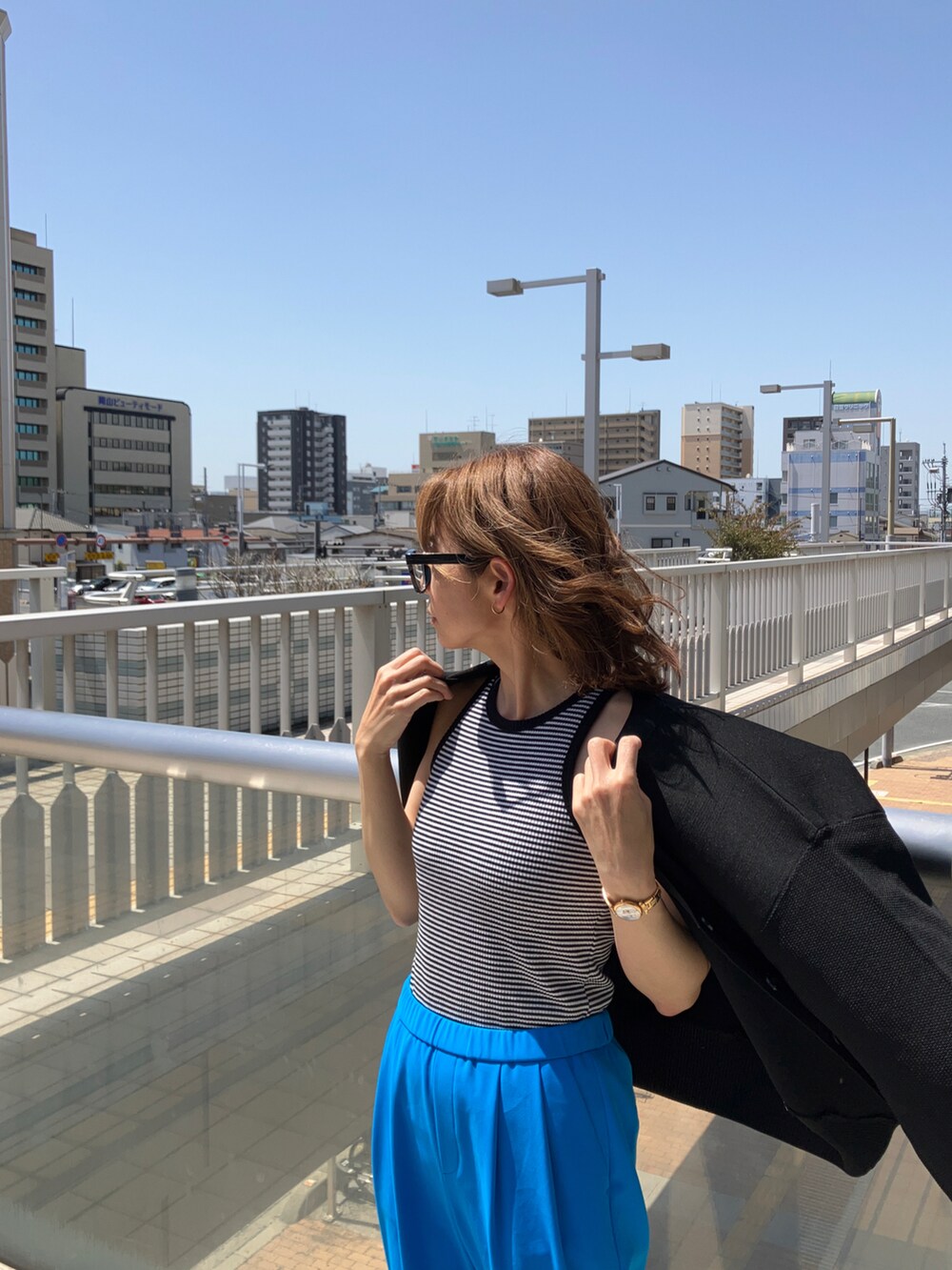 ブラック系のタンクトップ、ブルー系のその他パンツ、ブラック系のサンダルを着用したレディースの春コーディネートの4枚目の写真