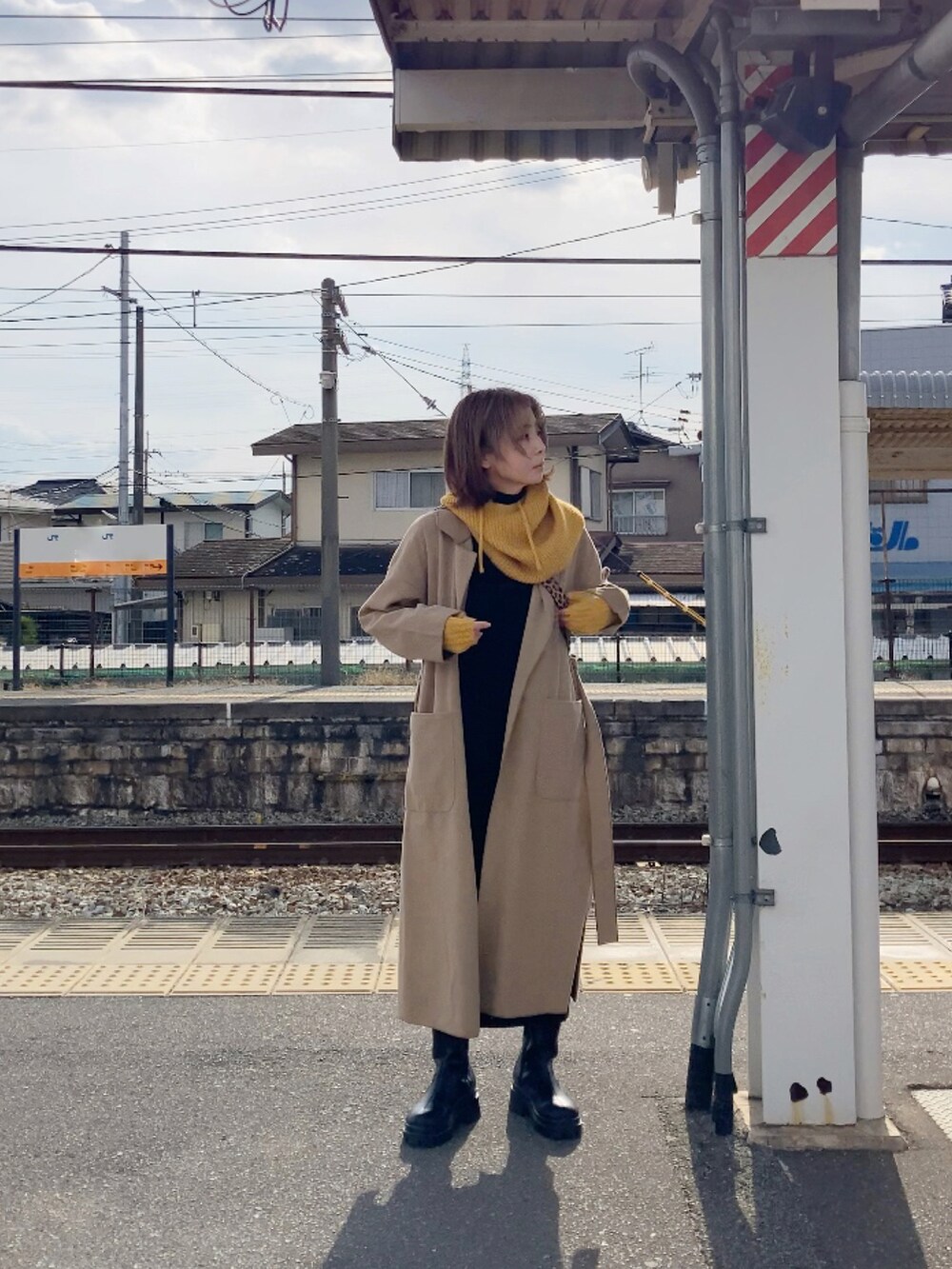 ベージュ系のジャケット/アウター、ブラック系のワンピース、ブラウン系のショルダーバッグを着用したレディースの冬コーディネートの3枚目の写真