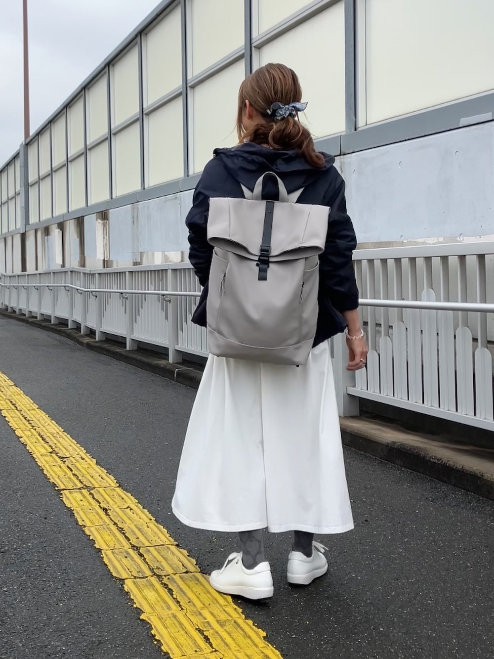 ホワイト系のスニーカー、ホワイト系のワンピース、ブルー系のマウンテンパーカーを着用したレディースの春コーディネートの2枚目の写真