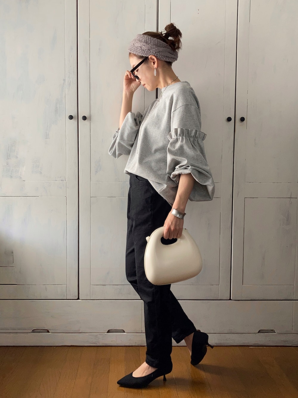 グレー系のTシャツ/カットソー、ブラック系のデニムパンツ、ホワイト系のバッグを着用したレディースの春コーディネートの2枚目の写真