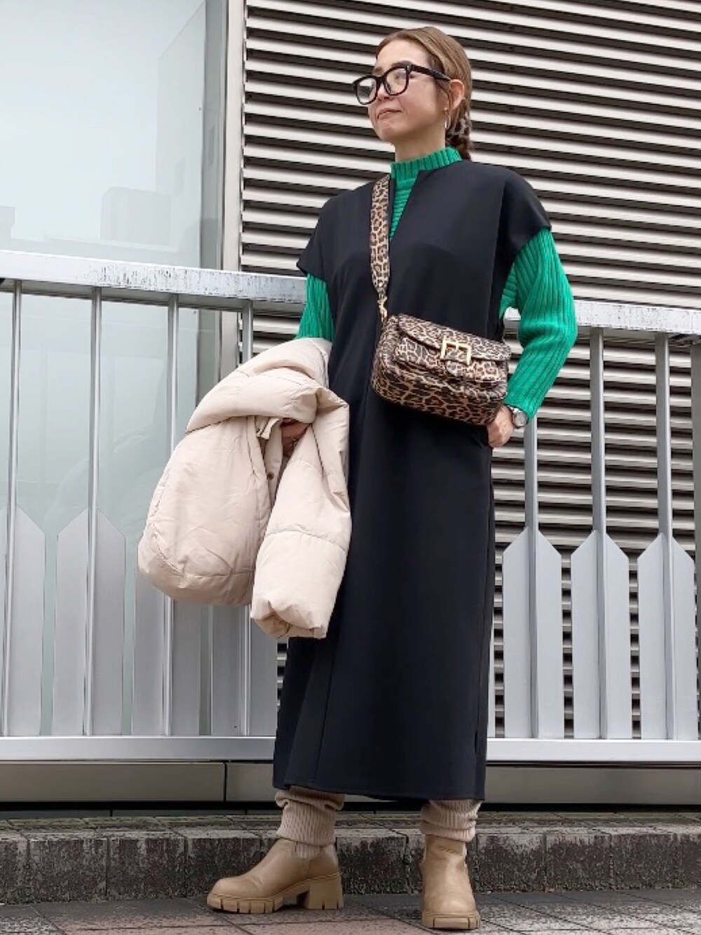 ブラック系のワンピース、グリーン系のニット/セーター、ブラウン系のショルダーバッグを着用したレディースの冬コーディネートの3枚目の写真