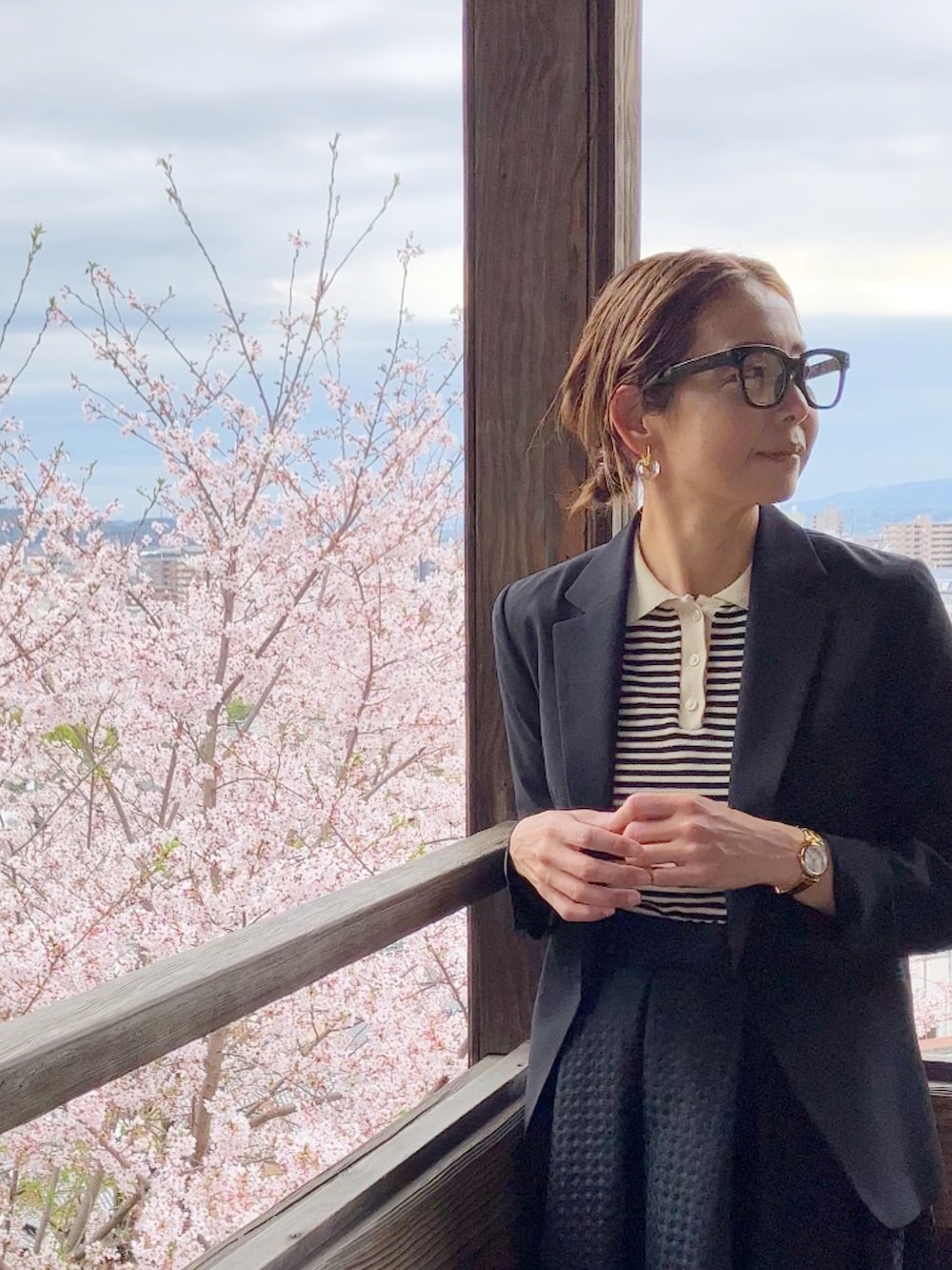 ブラック系のトップス、ブラック系のスカート、ブラック系のビジネスバッグを着用したレディースの春コーディネートの3枚目の写真