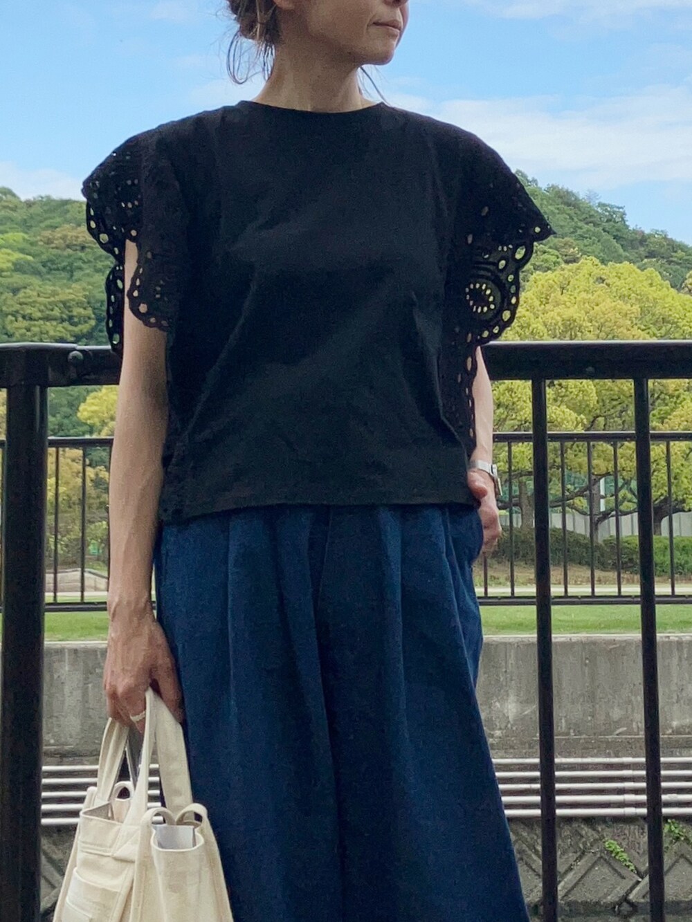 ブラック系のTシャツ/カットソー、ブルー系のデニムパンツ、ホワイト系のスニーカーを着用したレディースの春コーディネートの4枚目の写真