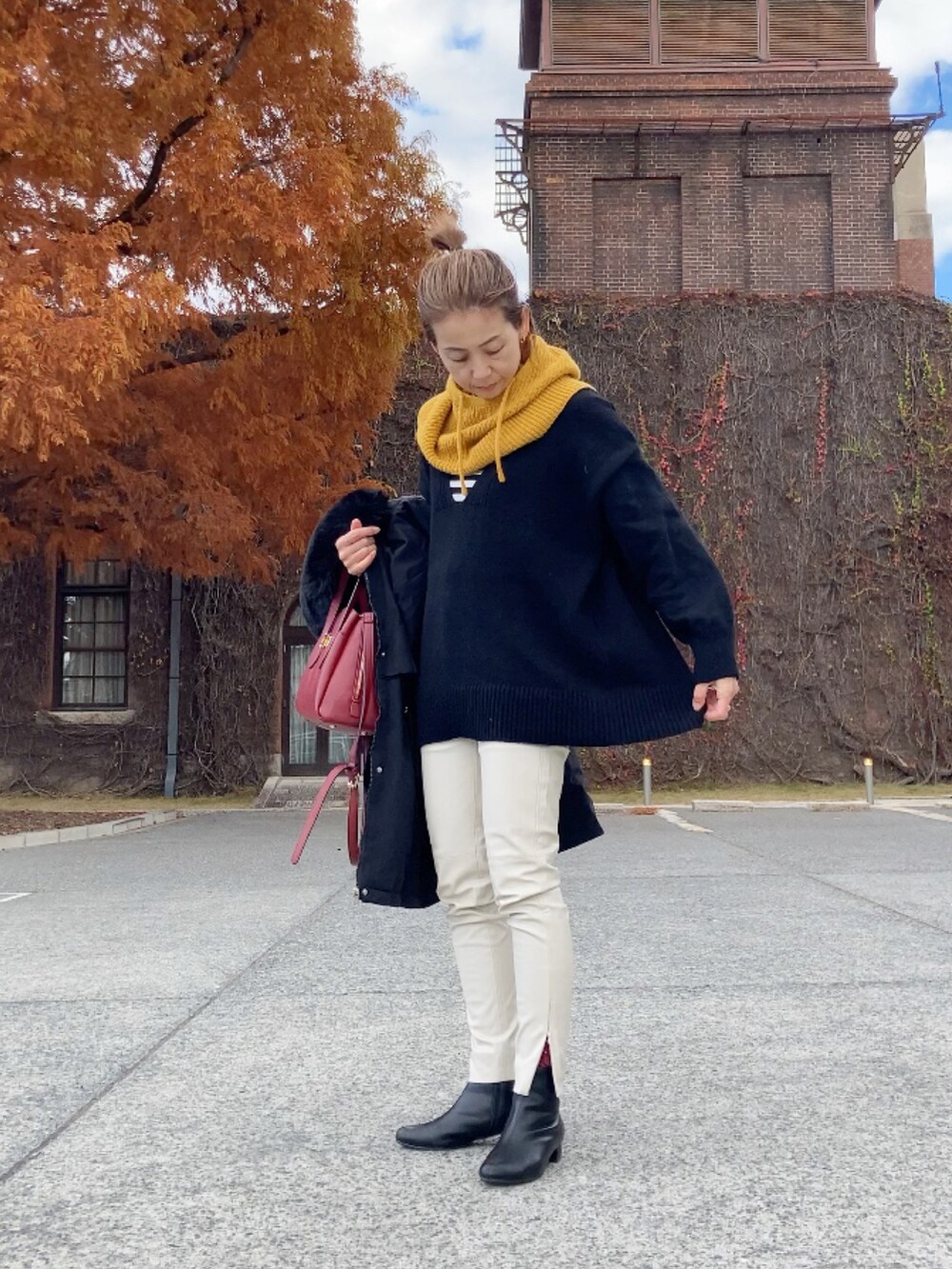 ブラック系のブルゾン、ブラック系のニット/セーター、ホワイト系のパンツを着用したレディースの冬コーディネートの2枚目の写真