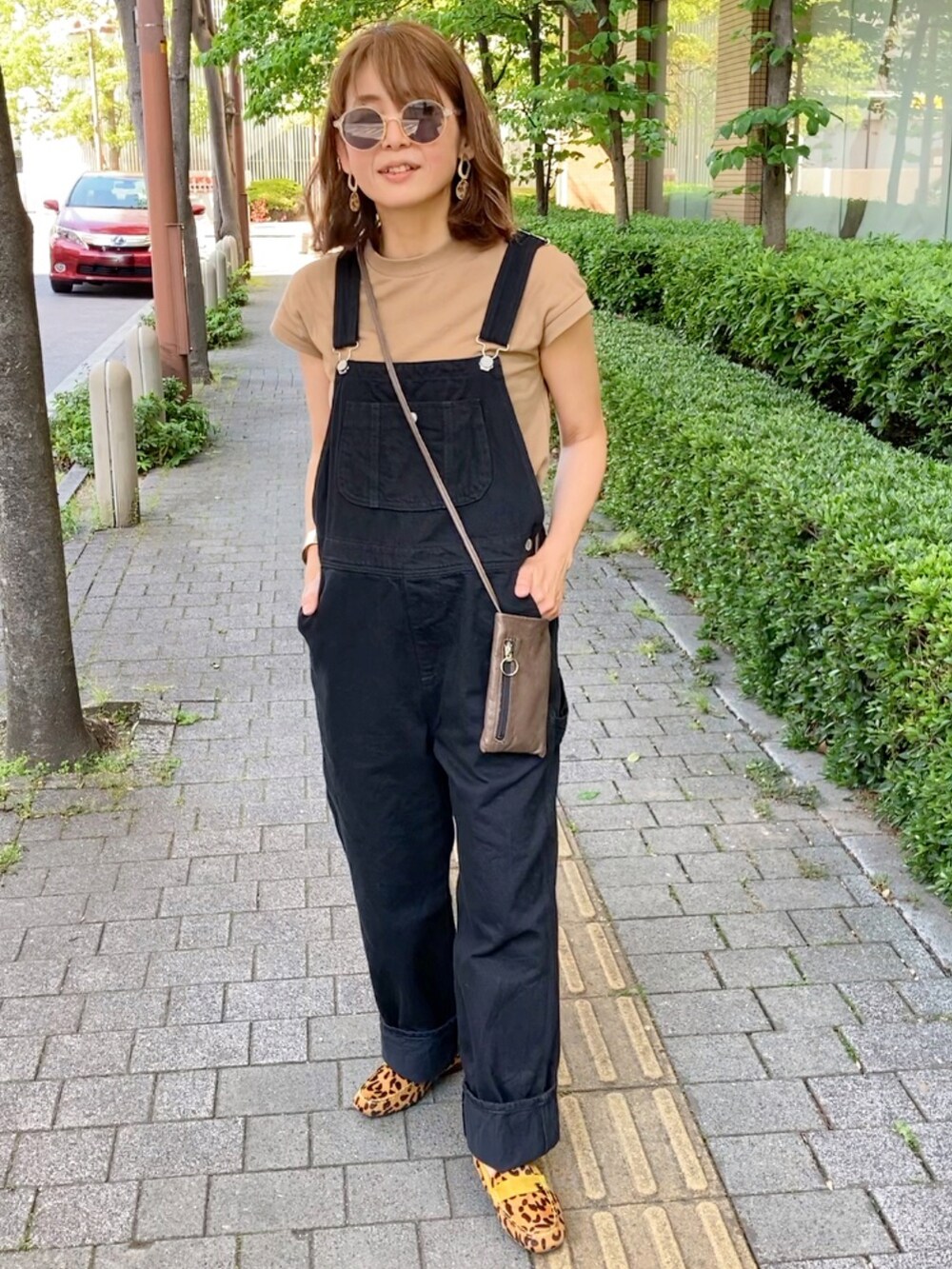 ベージュ系のローファー、ブラック系のサロペット/オーバーオール、ベージュ系のTシャツ/カットソーを着用したレディースの春コーディネートの2枚目の写真