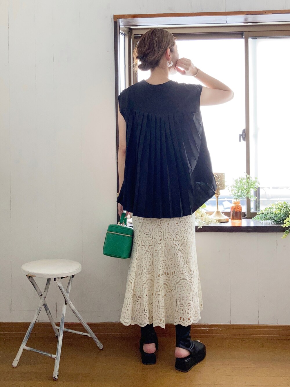 ブラック系のシャツ/ブラウス、グリーン系のショルダーバッグ、ホワイト系のスカートを着用したレディースの夏コーディネートの2枚目の写真