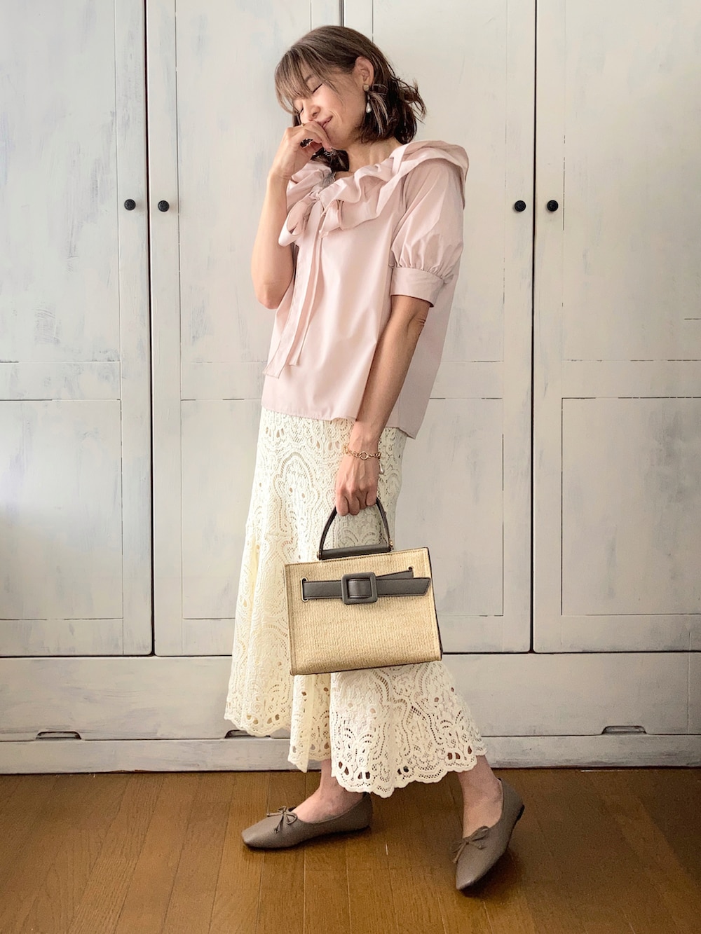 ベージュ系のシャツ/ブラウス、ホワイト系のスカート、グレー系のハンドバッグを着用したレディースの春コーディネートの2枚目の写真