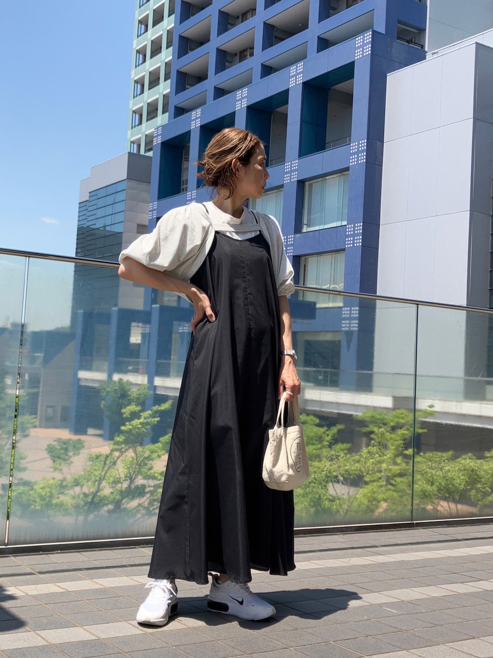 ブラック系のワンピース/ドレス、ホワイト系のTシャツ/カットソー、ホワイト系のスニーカーを着用したレディースの春コーディネートの2枚目の写真