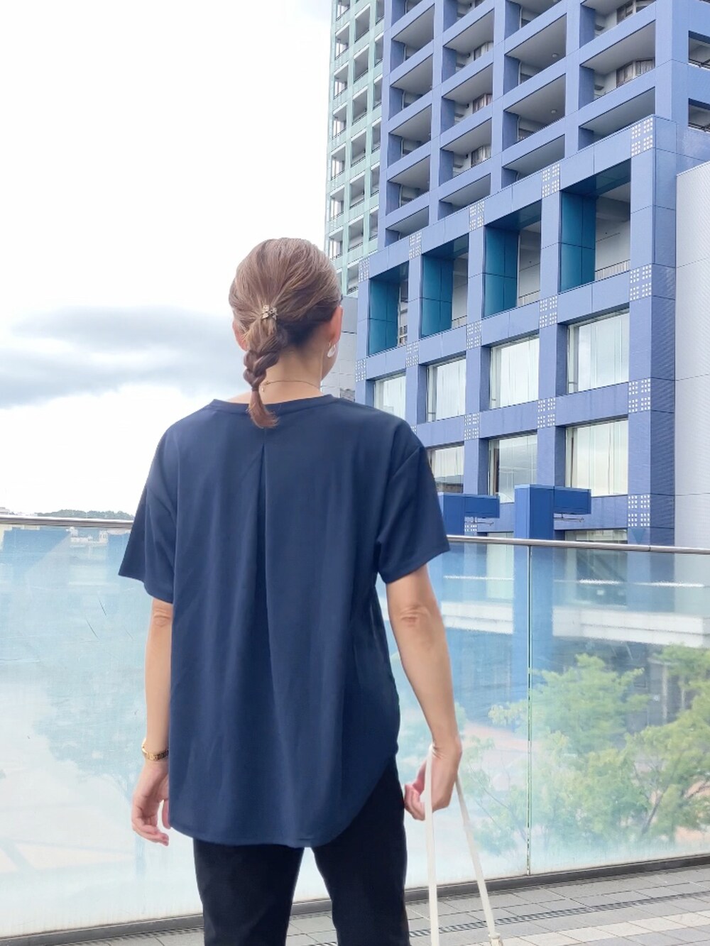 ブラック系のパンツ、ホワイト系のショルダーバッグ、ブラック系のパンツを着用したレディースの秋コーディネートの2枚目の写真