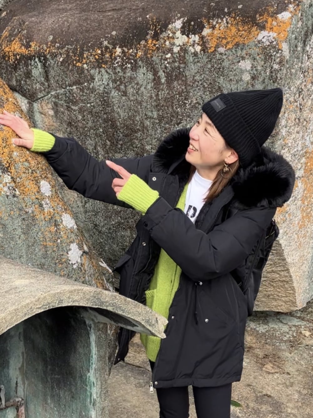 ブラック系のブルゾン、グリーン系のカーディガン/ボレロ、ホワイト系のTシャツ/カットソーを着用したレディースの冬コーディネートの3枚目の写真