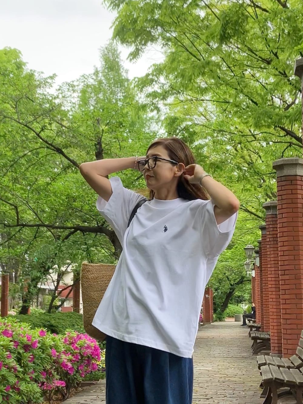 ホワイト系のTシャツ/カットソー、ブルー系のデニムパンツ、ブラック系のシューズを着用したレディースの春コーディネートの2枚目の写真