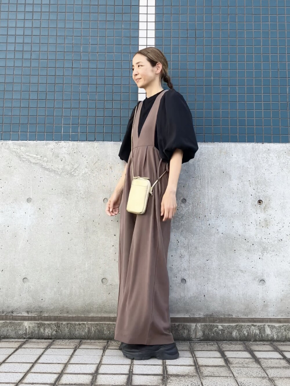ブラウン系のサロペット/オーバーオール、ブラック系のTシャツ/カットソー、ゴールド系のバッグを着用したレディースの夏コーディネートの4枚目の写真