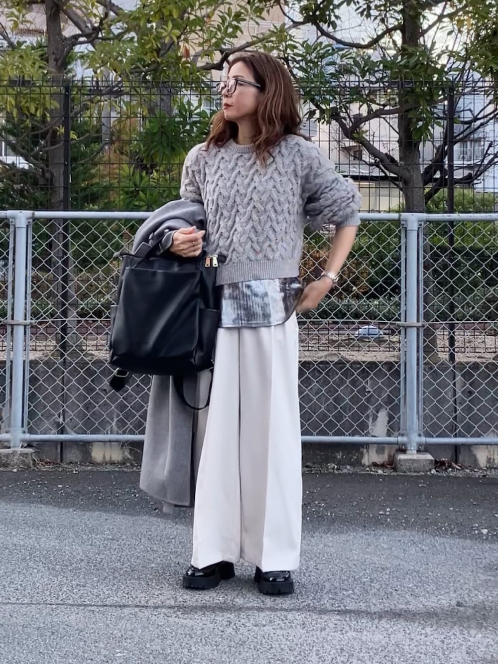 ホワイト系のその他パンツ、シルバー系のタンクトップ、ベージュ系のニット/セーターを着用したレディースの冬コーディネートの2枚目の写真