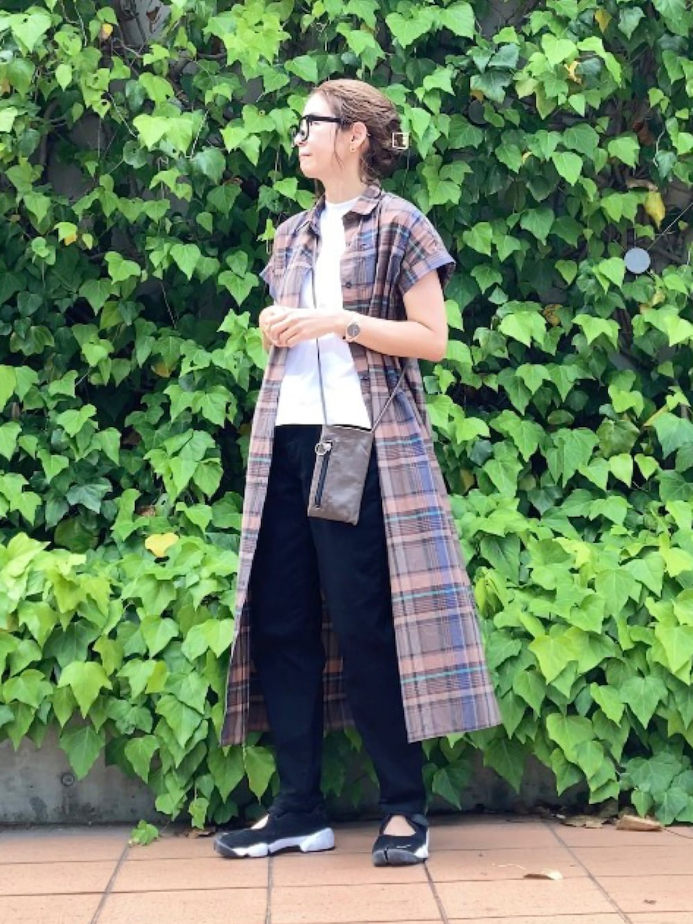 ブラウン系のワンピース、ホワイト系のTシャツ/カットソー、ブラック系のデニムパンツを着用したレディースの夏コーディネートの2枚目の写真