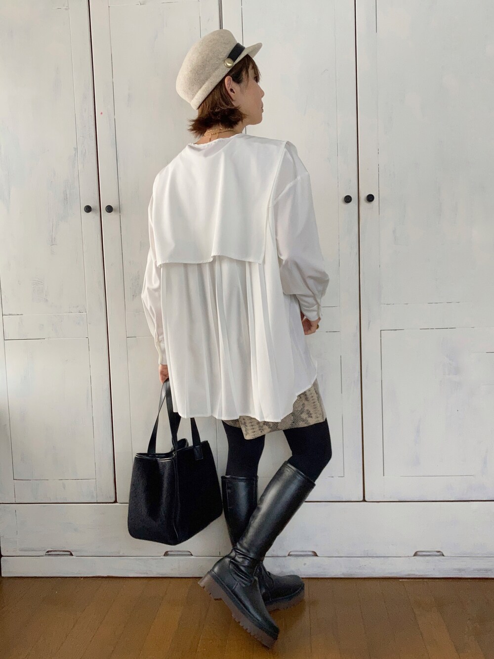 ホワイト系のシャツ/ブラウス、ブラック系のトートバッグ、ブラック系のブーツを着用したレディースの冬コーディネートの2枚目の写真