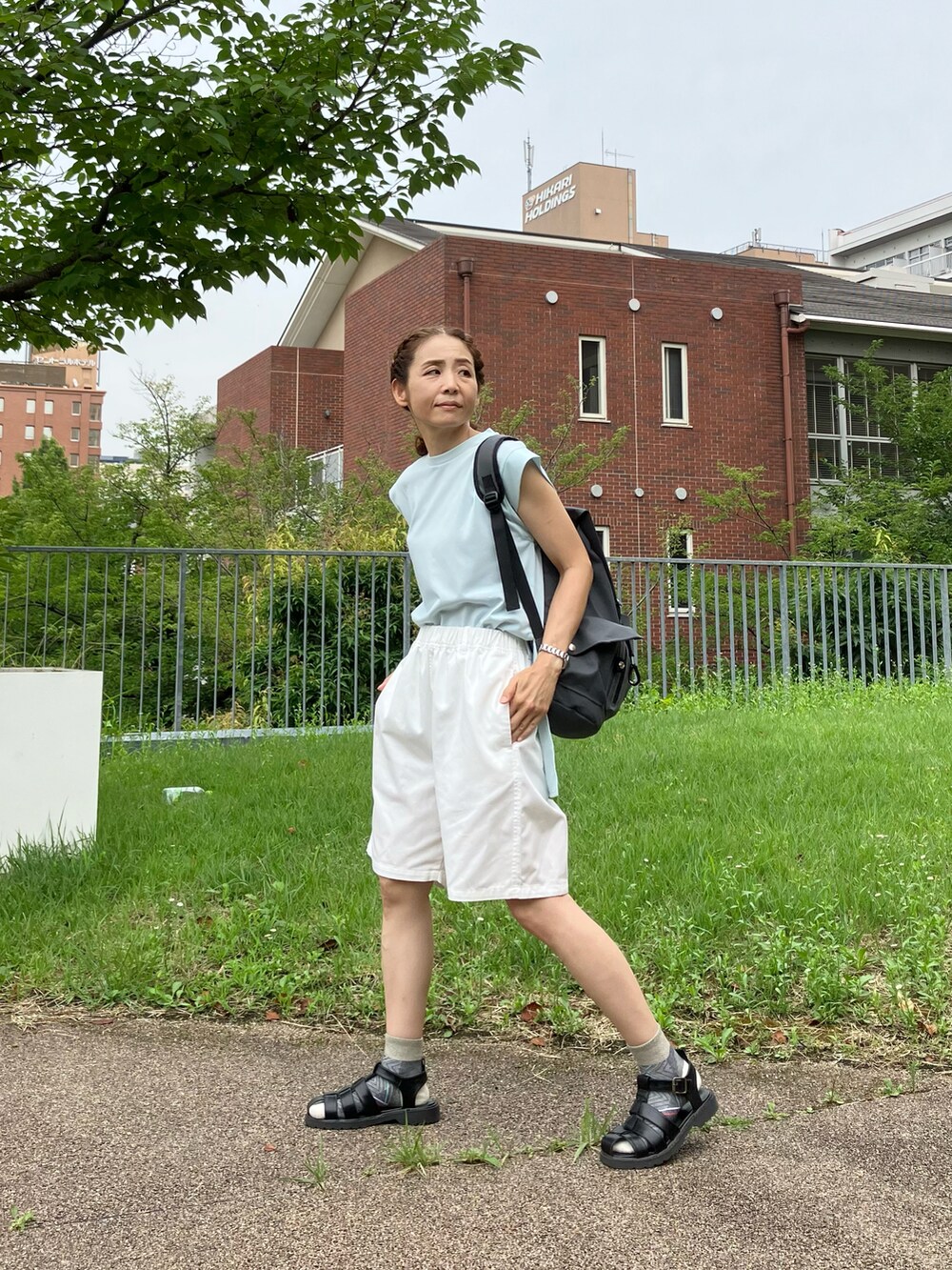 ブルー系のTシャツ/カットソー、ホワイト系のチノパンツ、グレー系のバックパック/リュックを着用したレディースの夏コーディネートの2枚目の写真