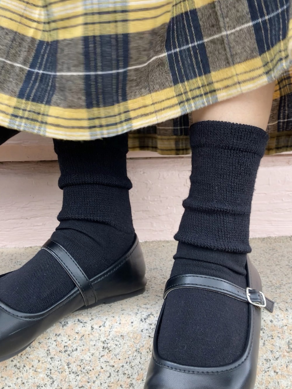 ホワイト系のスウェット、グレー系のベスト、イエロー系のスカートを着用したレディースの秋コーディネートの3枚目の写真