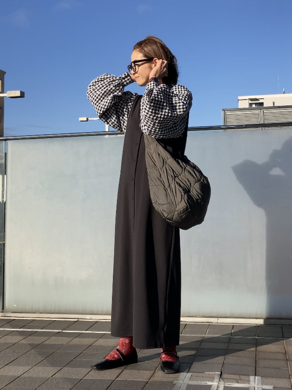 ブラック系のシャツ/ブラウス、ブラック系のジャンパースカート、グレー系のショルダーバッグを着用したレディースの秋コーディネートの3枚目の写真