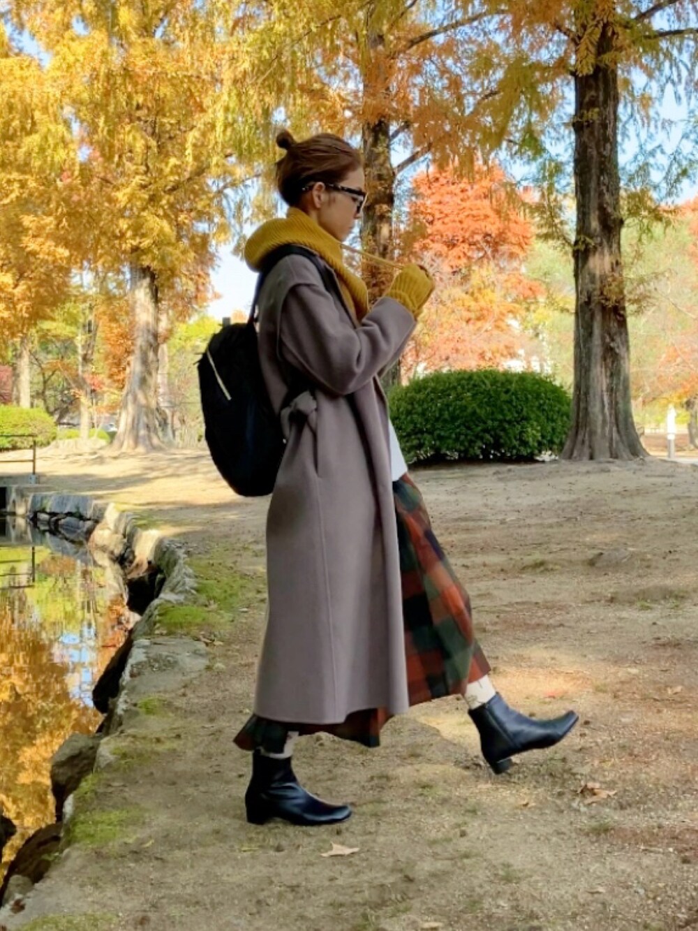 ブラウン系のチェスターコート、ブラック系のブーツ、ホワイト系のスウェットを着用したレディースの秋コーディネートの3枚目の写真