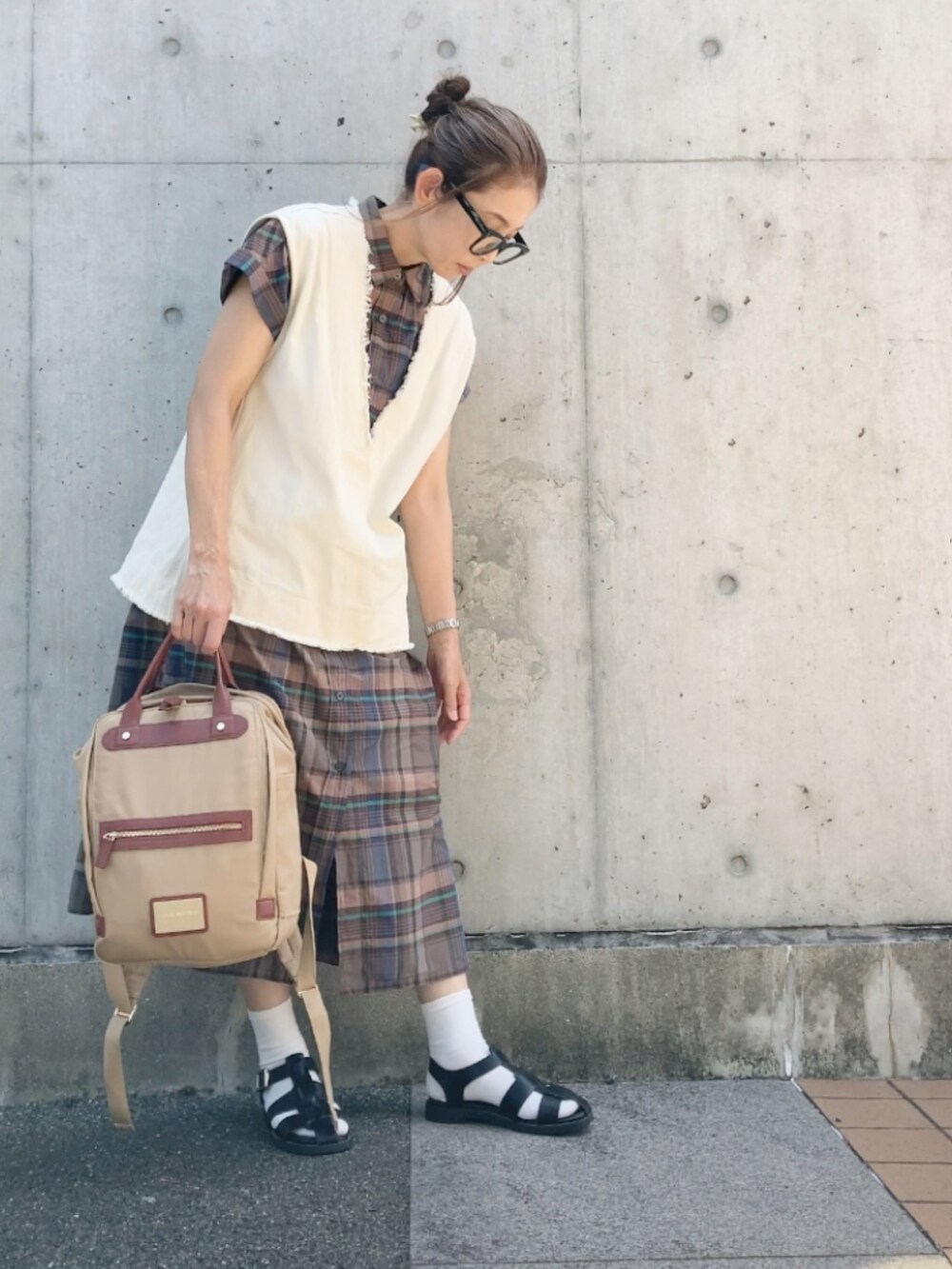 ベージュ系のベスト、ブラウン系のワンピース、ベージュ系のバックパック/リュックを着用したレディースの夏コーディネートの2枚目の写真