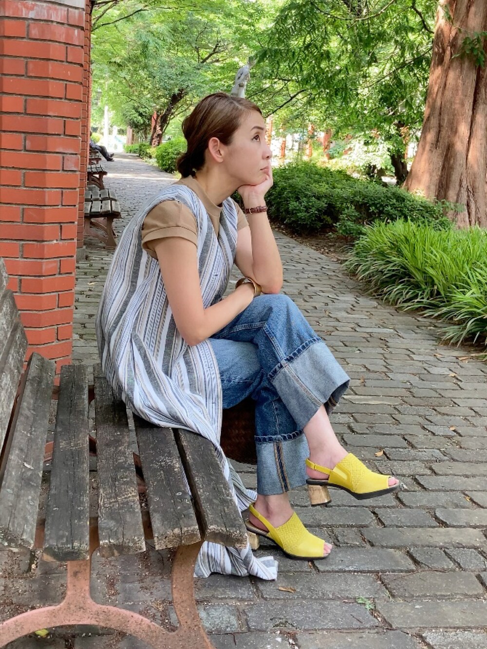 ホワイト系のワンピース、ブルー系のデニムパンツ、イエロー系のサンダルを着用したレディースの夏コーディネートの3枚目の写真