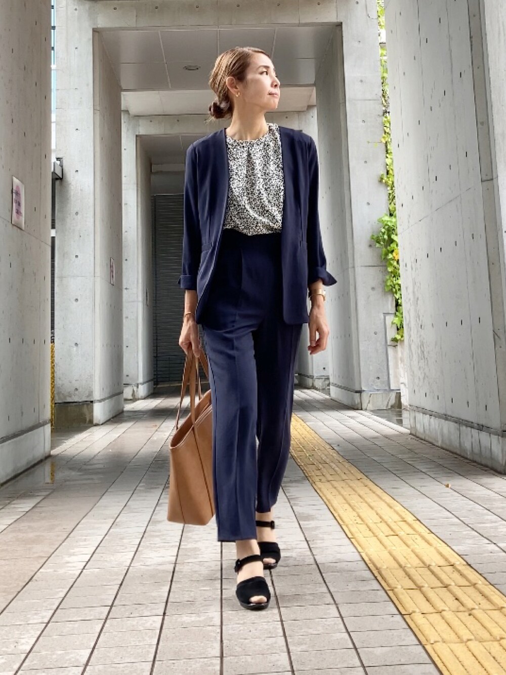 ブルー系のスーツセット、ホワイト系のシャツ/ブラウス、ブラック系のサンダルを着用したレディースの夏コーディネートの3枚目の写真