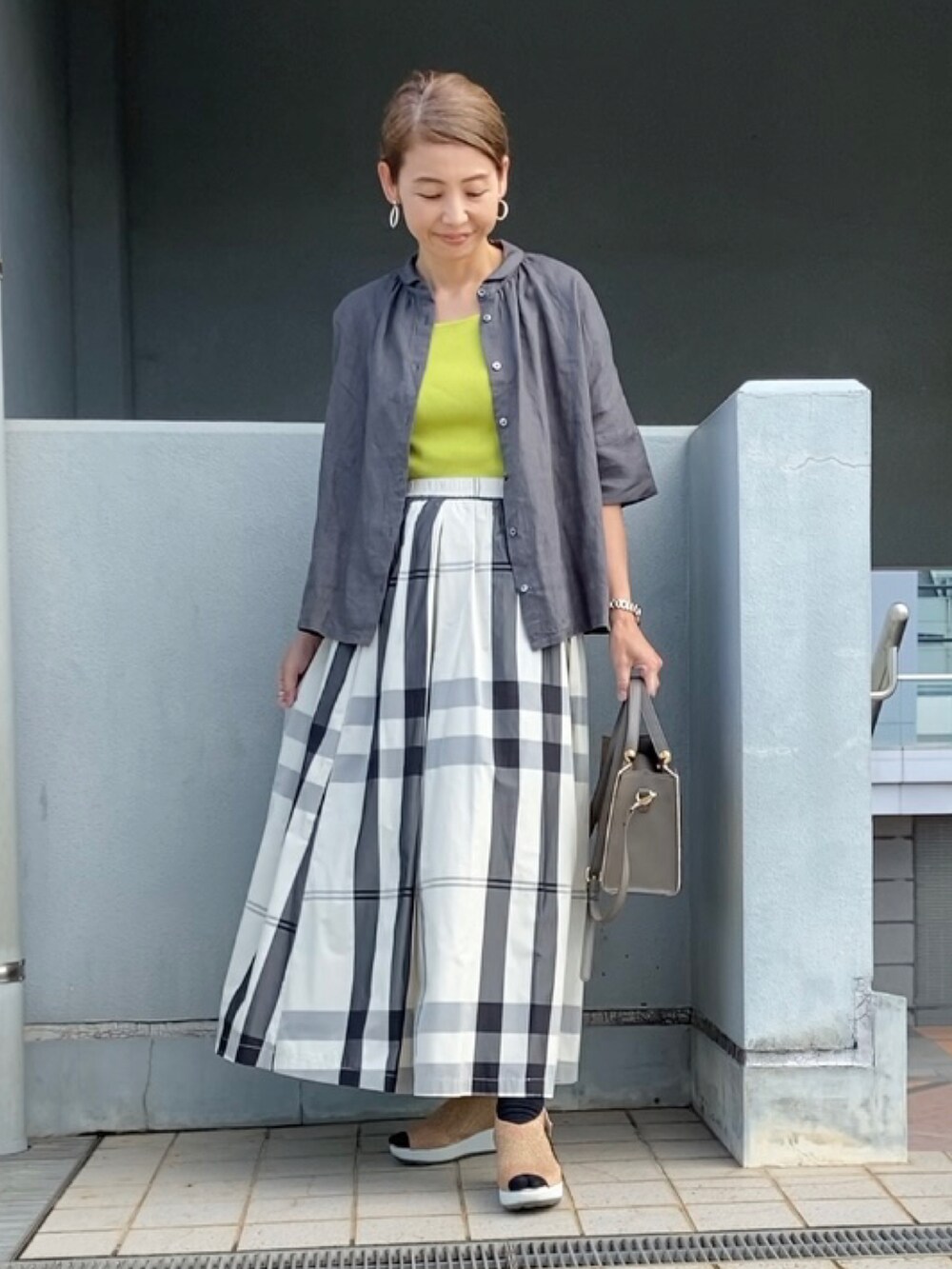 グレー系のシャツ/ブラウス、ホワイト系のスカート、グリーン系のタンクトップを着用したレディースの夏コーディネートの4枚目の写真