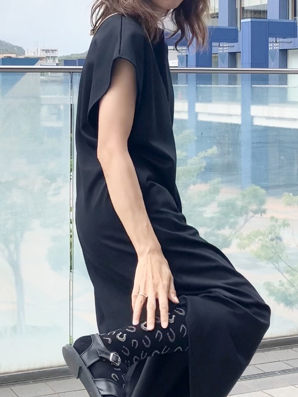 ブラック系のワンピース、ゴールド系のバッグ、ブラック系のサンダルを着用したレディースの秋コーディネートの3枚目の写真