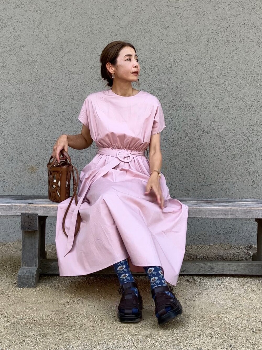 ピンク系のワンピース/ドレス、ブラウン系のサンダル、ブラウン系のバッグを着用したレディースの夏コーディネートの2枚目の写真