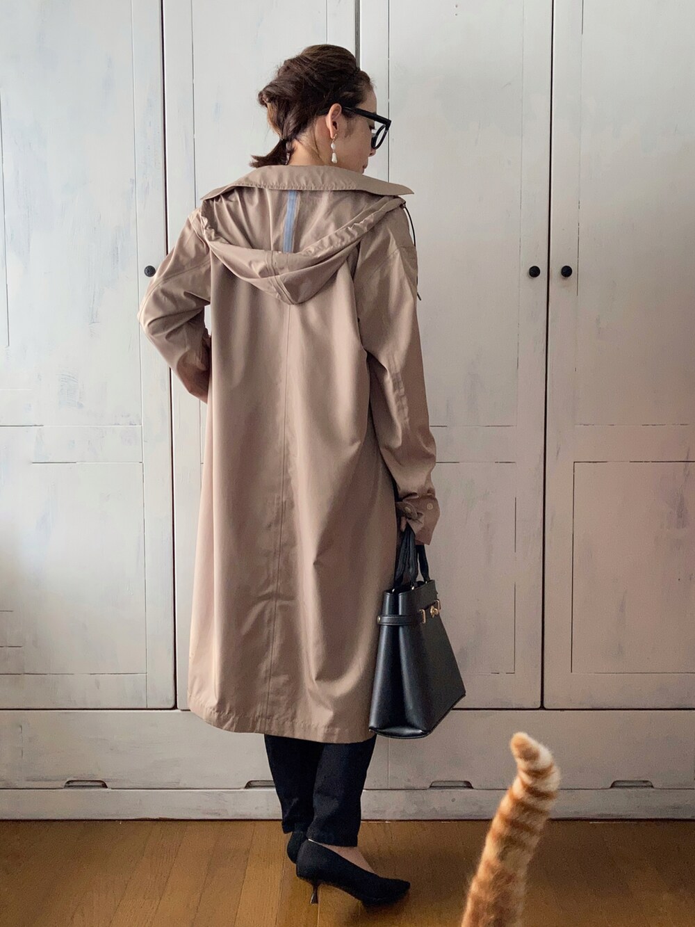 ホワイト系のニット/セーター、ブラック系のデニムパンツ、ブラック系のパンプスを着用したレディースの春コーディネートの2枚目の写真