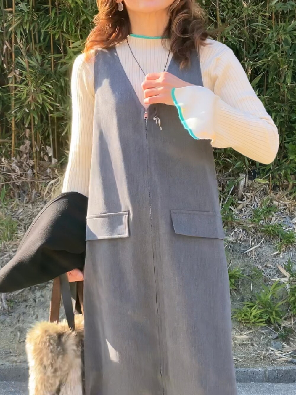 グレー系のワンピース、ホワイト系のニット/セーターを着用したレディースの冬コーディネートの2枚目の写真