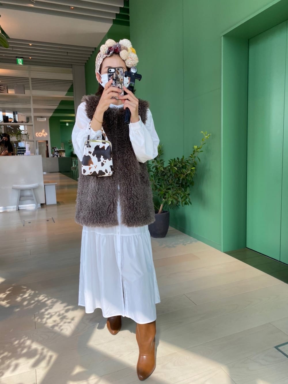 グレー系のベスト、イエロー系のブーツ、ベージュ系のヘアバンドを着用したレディースの秋コーディネートの2枚目の写真