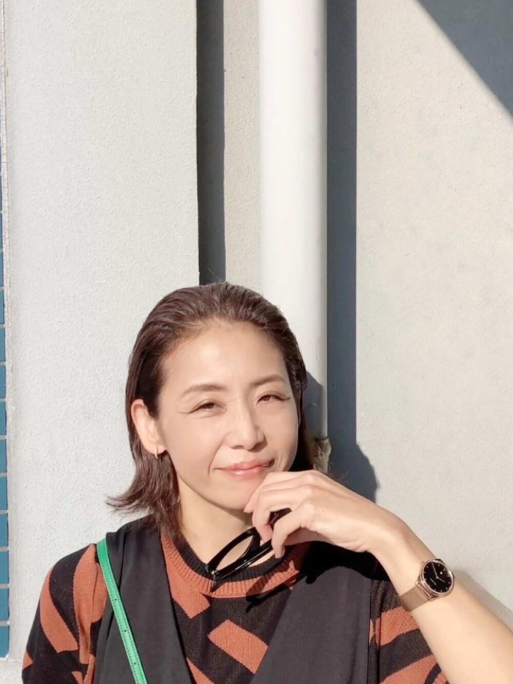 ブラウン系のその他トップス、ブラック系のジャンパースカート、グリーン系のショルダーバッグを着用したレディースの秋コーディネートの3枚目の写真